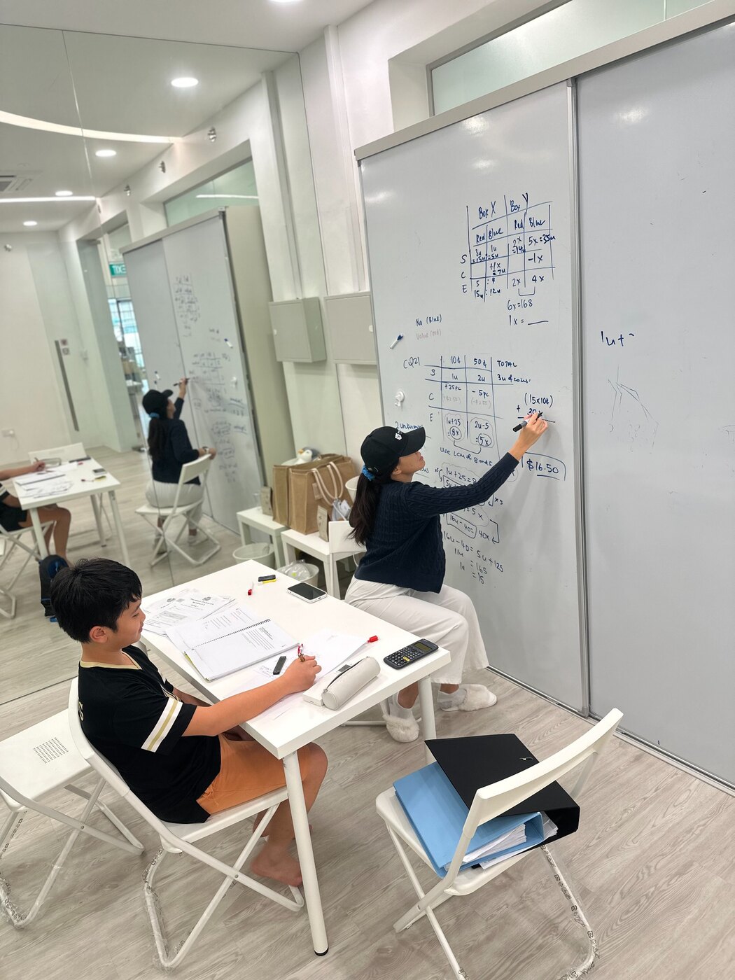 Ms Joyce guiding a child through a mathematics lesson at ProgressLab
