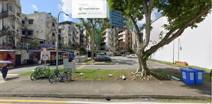 Beatty Road carpark reference view showing open-air lots beside a large tree and white wall