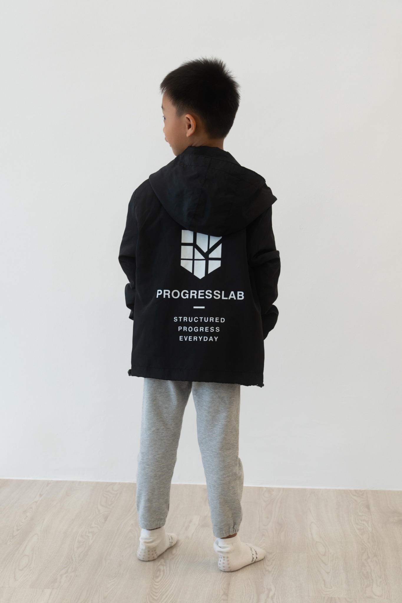 Child wearing the black ProgressLab windbreaker, currently out of stock