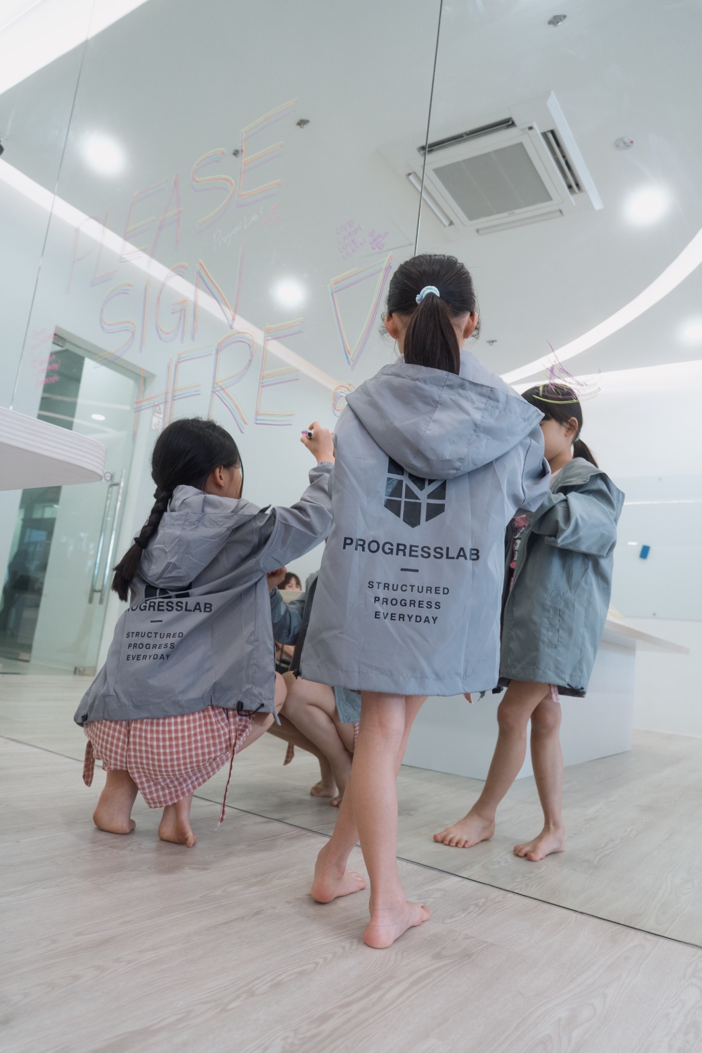 Children wearing ProgressLab windbreakers inside the centre