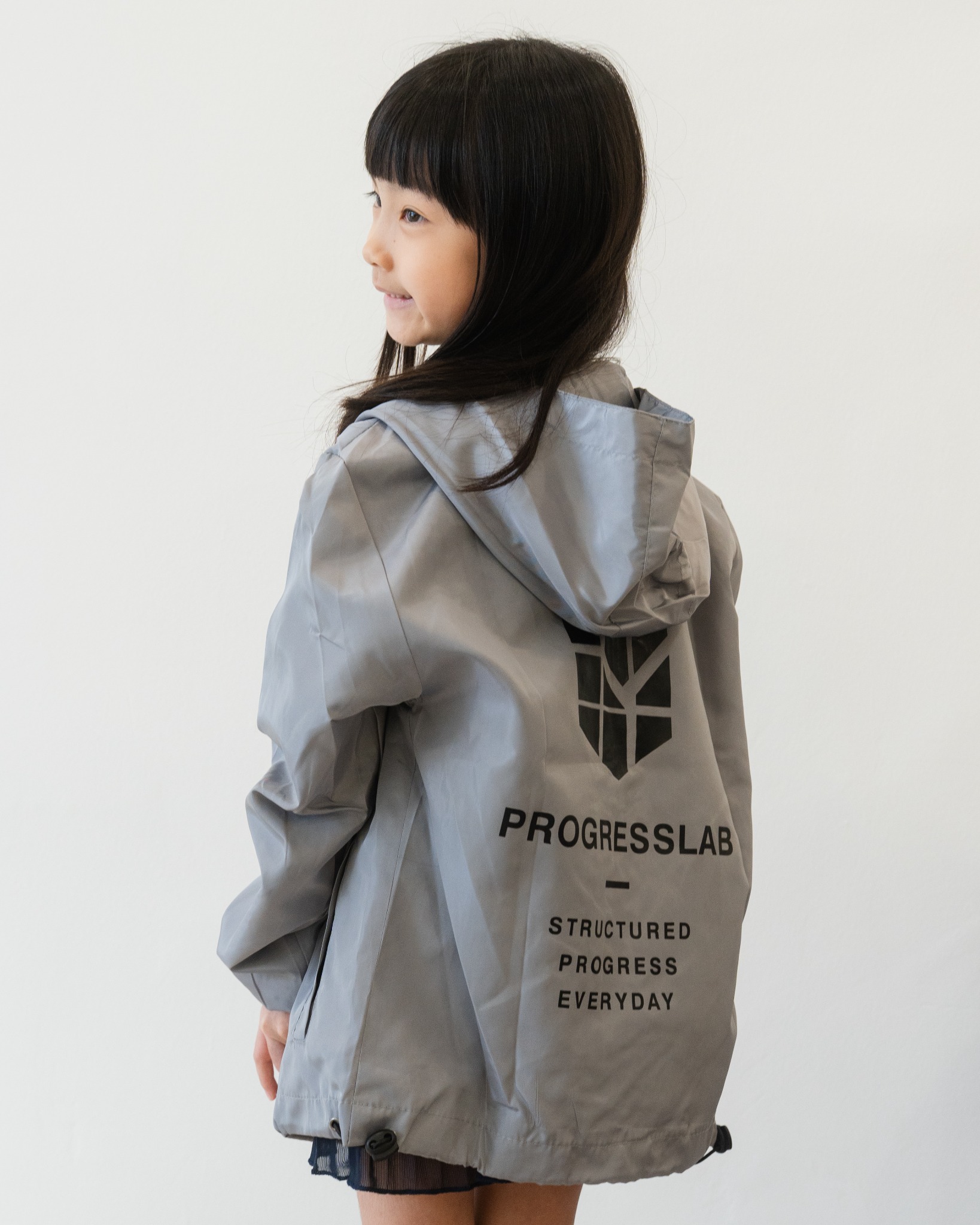 Child showing the back of the grey ProgressLab windbreaker